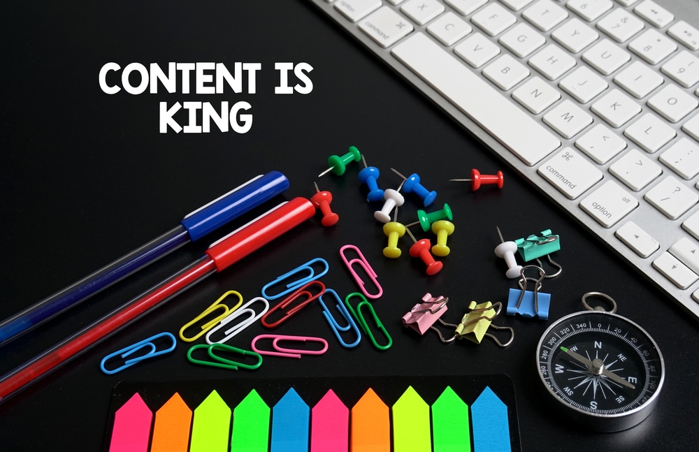 Content is King! A Keyboard and Various Office Supplies.